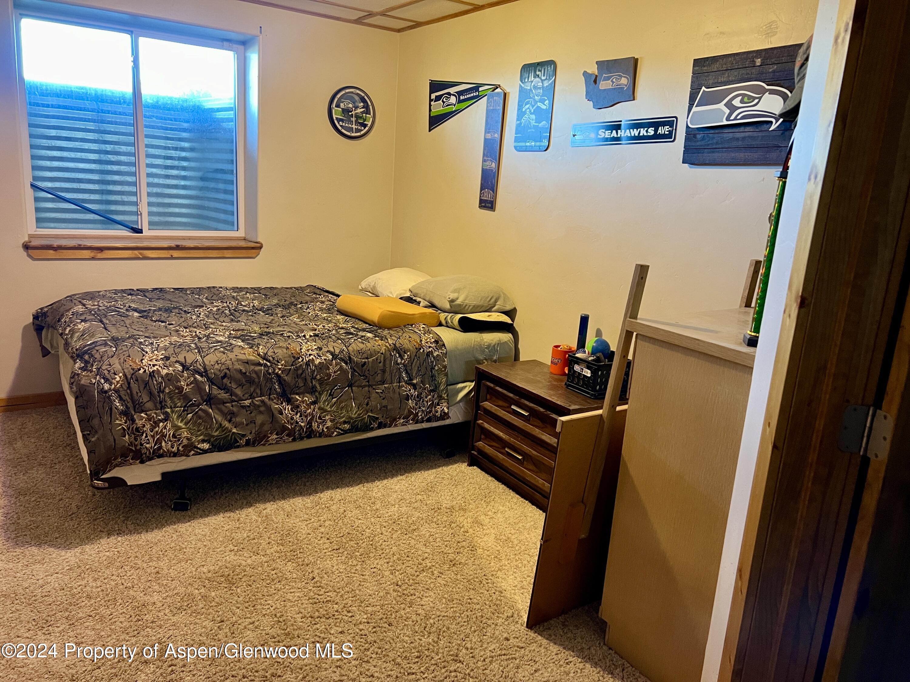 709 Rimrock Drive Meeker, CO 81641 - Photo 18 of 27 a bedroom with a bed and wooden floor