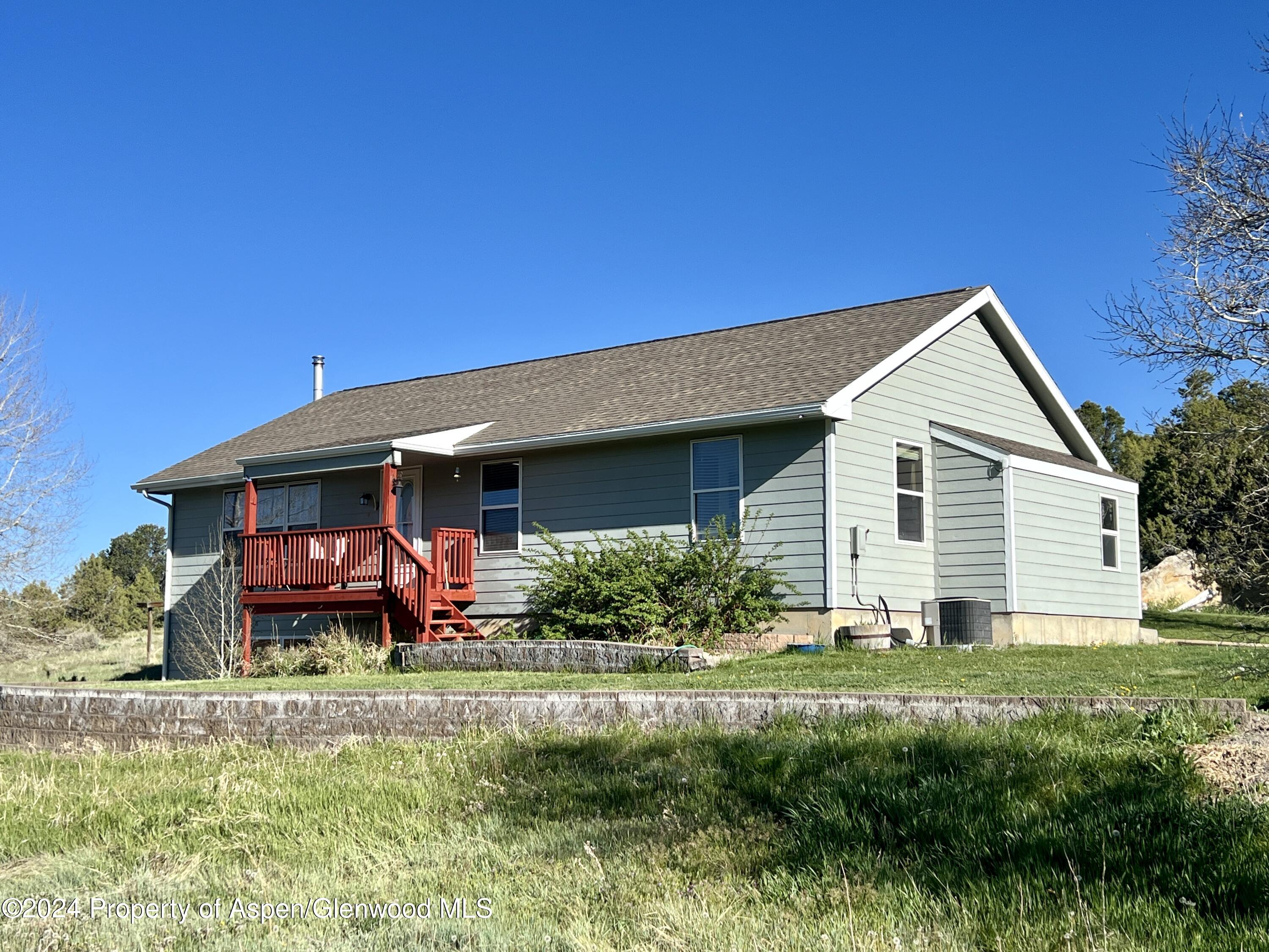 709 Rimrock Drive Meeker, CO 81641 - Photo 2 of 27 a front view of a house with a yard and potted plants