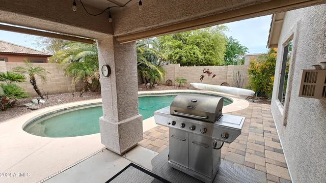 a view of backyard with a chair and potted plants