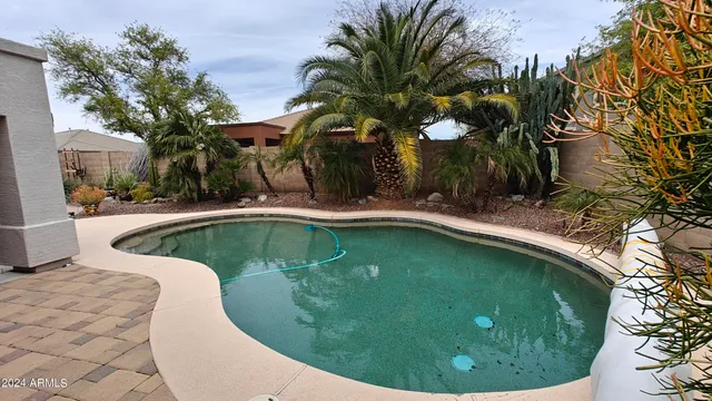 a living room with furniture a chandelier fan and a window