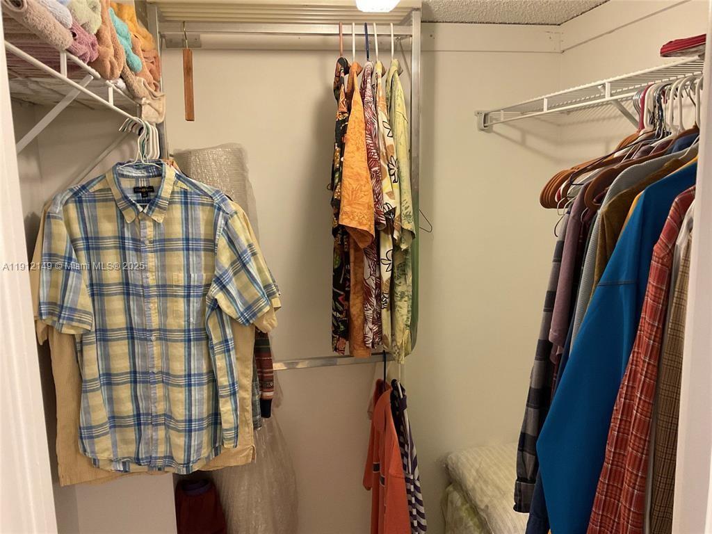 3080 North Course Drive, Unit 209 Pompano Beach, FL 33069 - Photo 11 of 35 a view of walk in closet with clothes and shoes