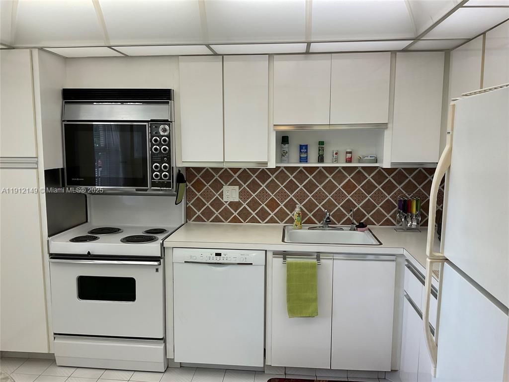 3080 North Course Drive, Unit 209 Pompano Beach, FL 33069 - Photo 13 of 35 a kitchen with a stove and a microwave