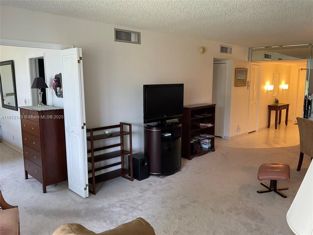 3080 North Course Drive, Unit 209 Pompano Beach, FL 33069 - Photo 2 of 35 a living room with furniture and a flat screen tv