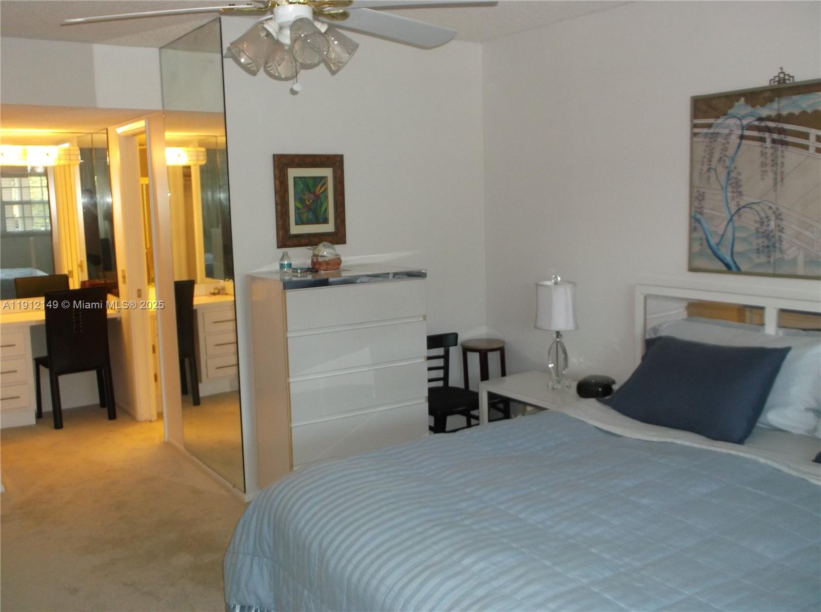3080 North Course Drive, Unit 209 Pompano Beach, FL 33069 - Photo 10 of 35 a bedroom with a bed and a chandelier