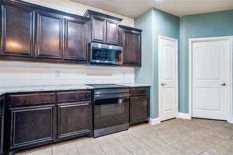 a kitchen with granite countertop wooden cabinets and stainless steel appliances