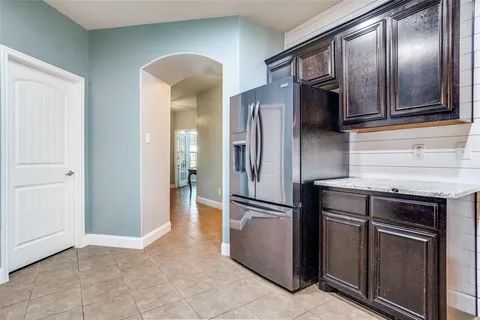 a kitchen with stainless steel appliances granite countertop a refrigerator a stove and a sink