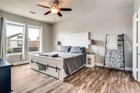 a spacious bedroom with a bed and wooden floor