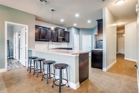 a kitchen with stainless steel appliances kitchen island granite countertop a refrigerator and a sink