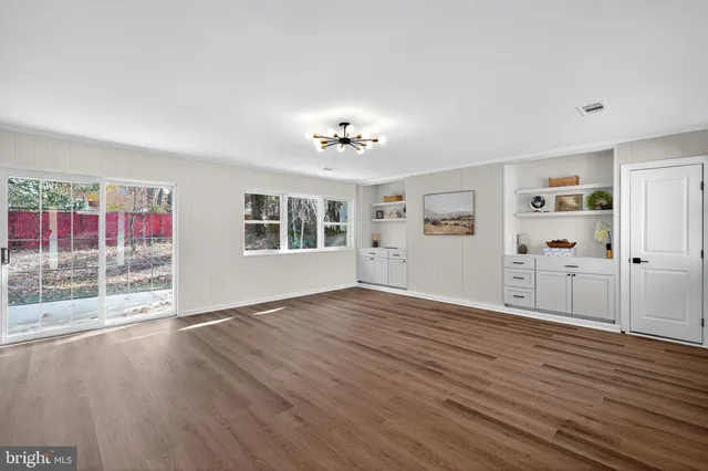 a view of a livingroom with wooden floor and a ceiling fan