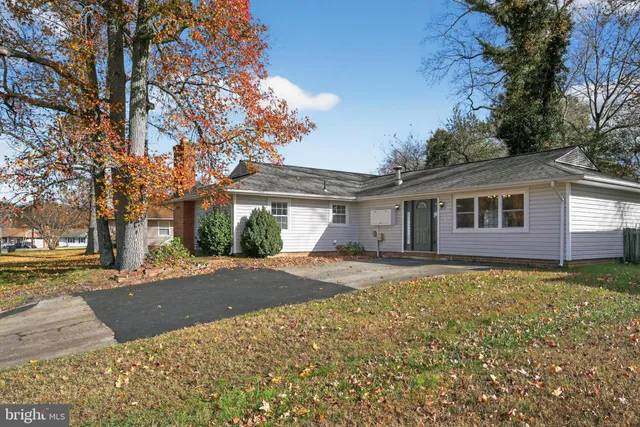 a view of a house with a yard and large tree