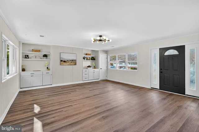 a view of a big room with wooden floor and windows