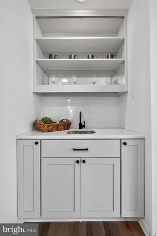 a kitchen with white cabinets and a wooden floor