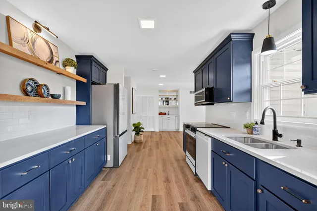 a kitchen with stainless steel appliances a sink stove and wooden cabinets
