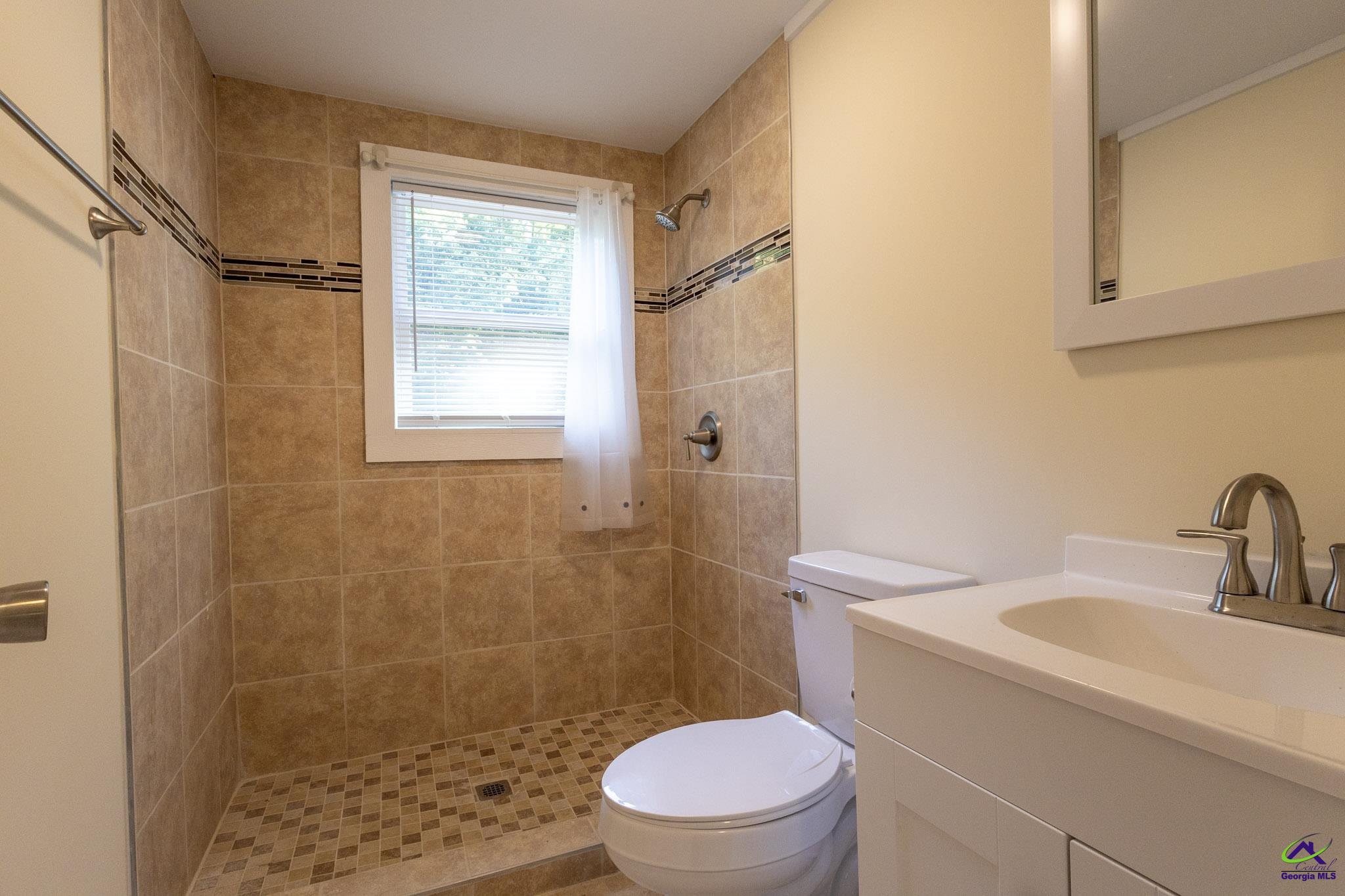 156 Churchwell Road Cochran, GA 31014 - Photo 13 of 20 a bathroom with a sink a toilet a window and shower