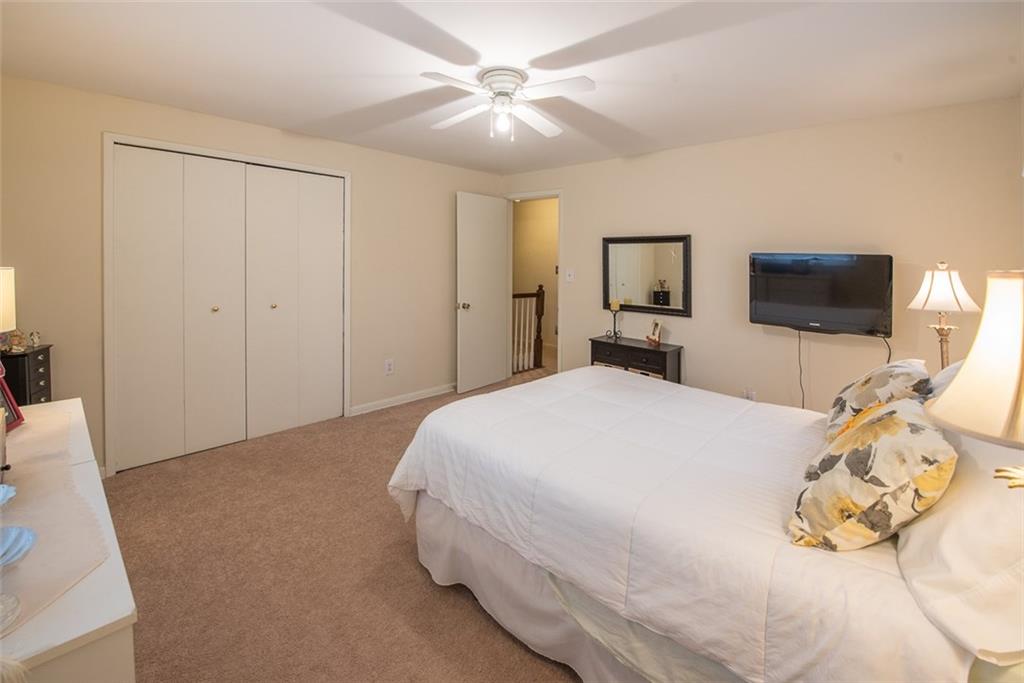 2371 Harrison City Road Export, PA 15632 - Photo 17 of 25 Secondary Bedroom Facing Front of Home with Double Closet, Ceiling Fan and Neutral Carpet and Paint.