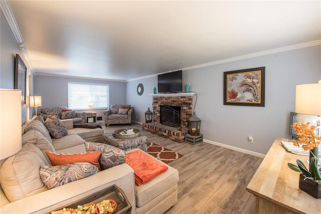 2371 Harrison City Road Export, PA 15632 - Photo 5 of 25 Huge, Family Room Measures 24x13 with the same Newer Laminate wood-loo floors and Crown Molding, Plus Brick Fireplace. Updated Grey Paint and White Trim.