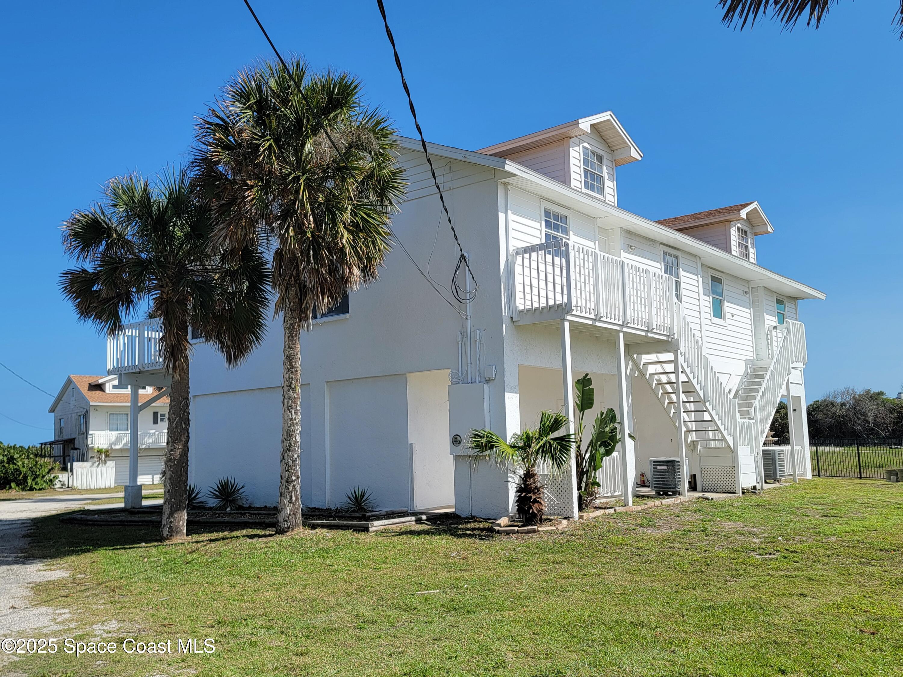 8517 Jimmy Buffett Mem Highway Melbourne Beach, FL 32951 - Photo 13 of 60 a front view of a house with a yard