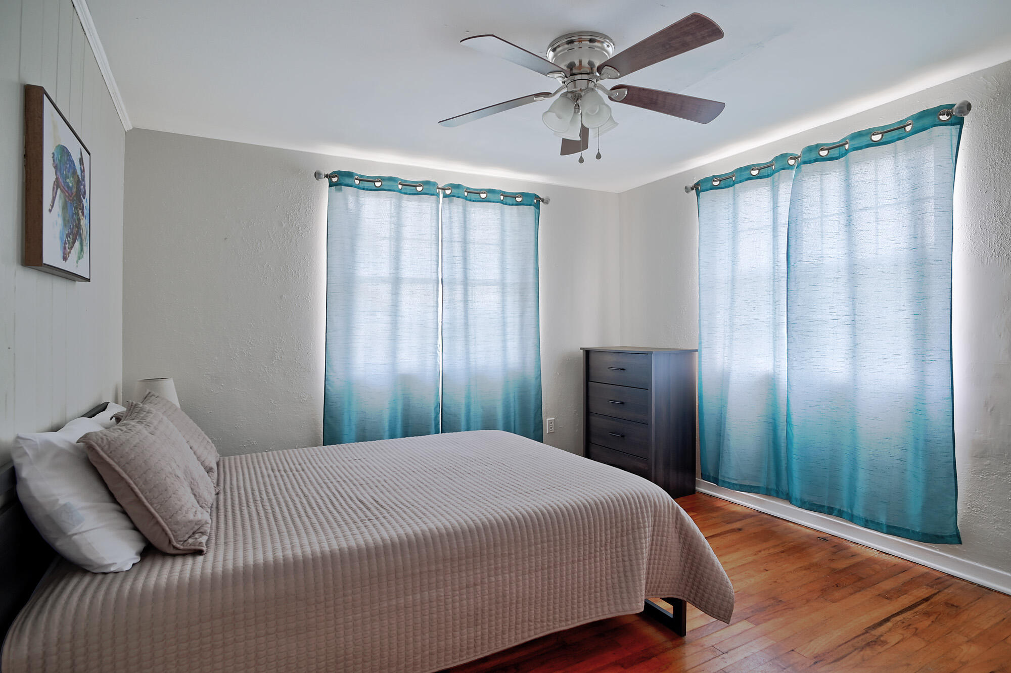 8517 Jimmy Buffett Mem Highway Melbourne Beach, FL 32951 - Photo 25 of 60 a bedroom with a large bed and a chandelier