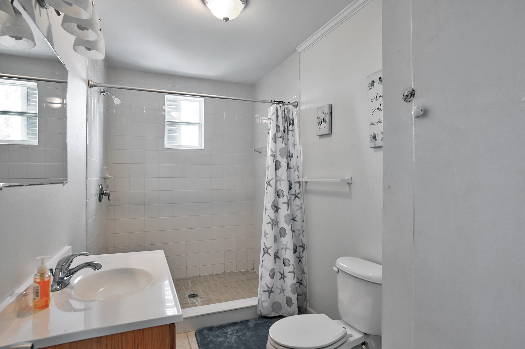 8517 Jimmy Buffett Mem Highway Melbourne Beach, FL 32951 - Photo 29 of 60 a bathroom with a sink toilet and shower