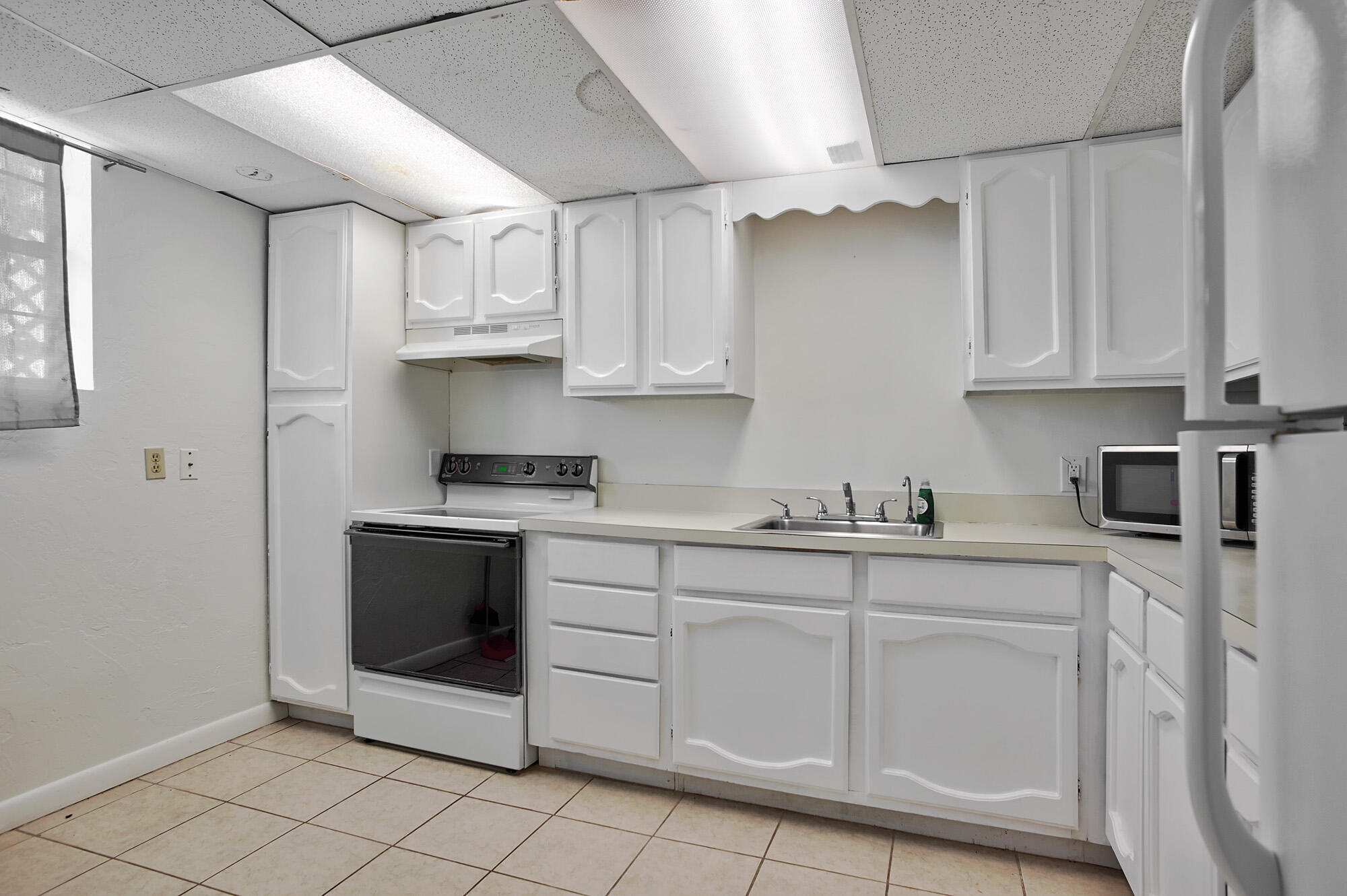 8517 Jimmy Buffett Mem Highway Melbourne Beach, FL 32951 - Photo 32 of 60 a kitchen with white cabinets and white appliances