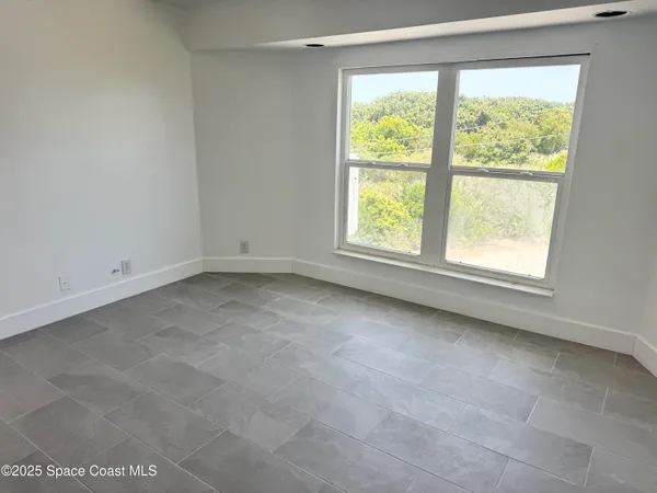a living room with furniture a flat screen tv and a window