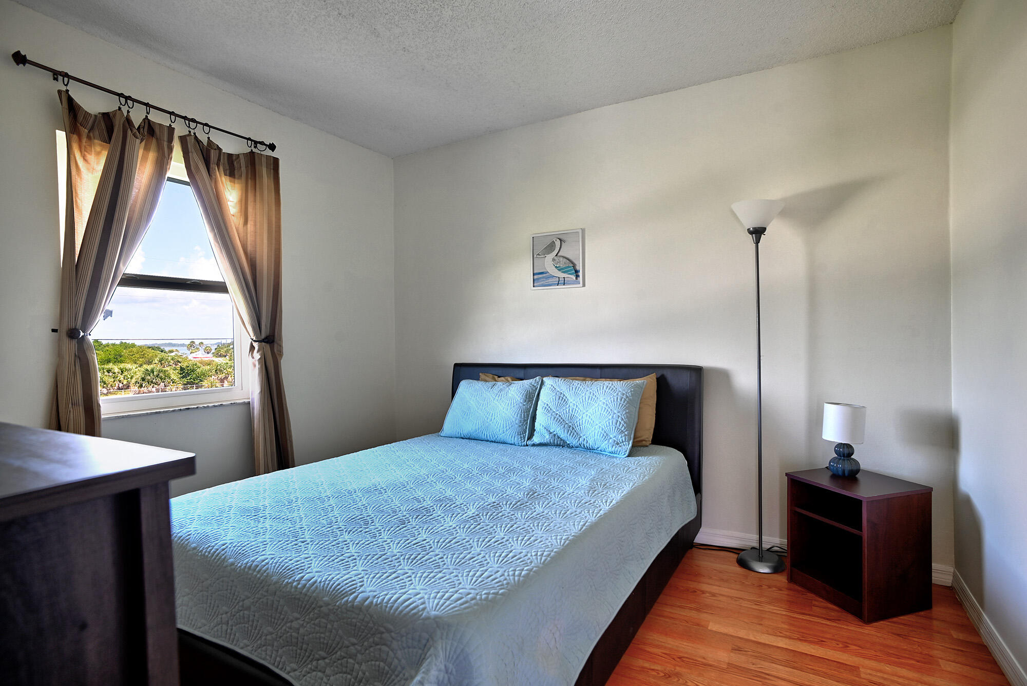 8517 Jimmy Buffett Mem Highway Melbourne Beach, FL 32951 - Photo 53 of 60 a bed sitting in a bedroom next to a window