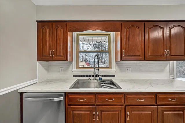 a kitchen with stainless steel appliances granite countertop cabinets and window