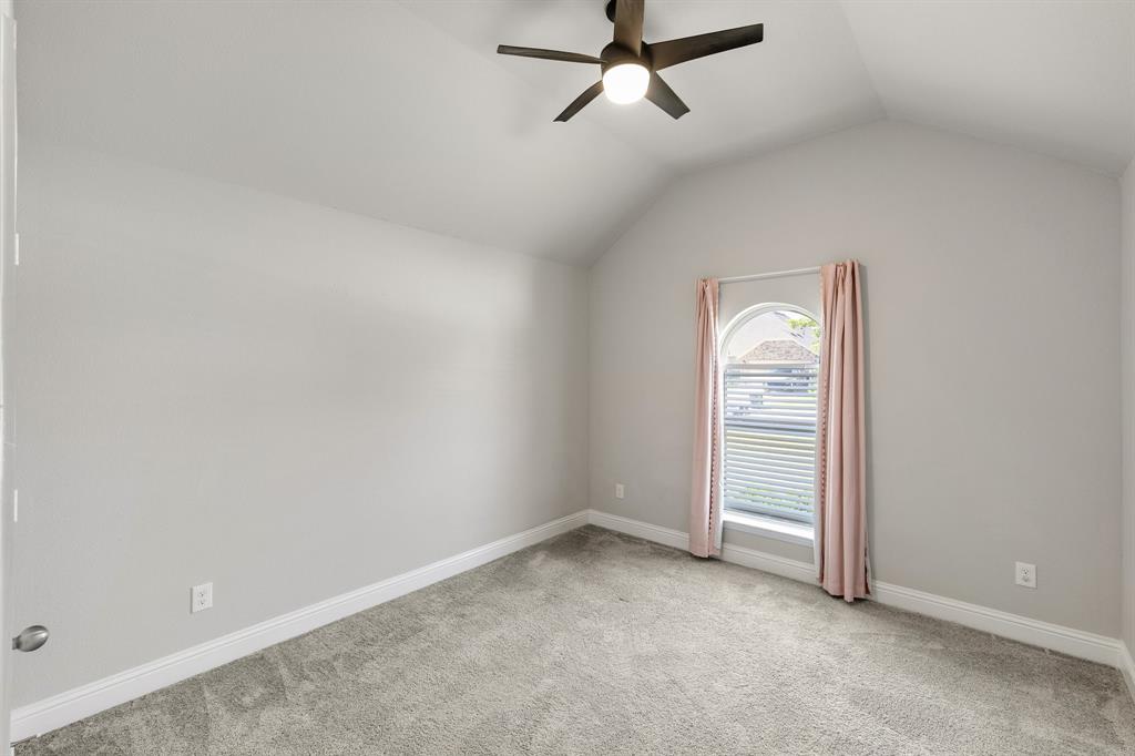 915 Timber Ridge Drive Justin, TX 76247 - Photo 32 of 39 Vaulted ceiling room featuring a contemporary ceiling fan with lighting, an arched window, and neutral-toned carpeting