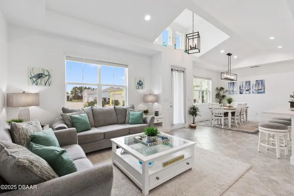 a view of a livingroom and dining room with furniture wooden floor and a chandelier