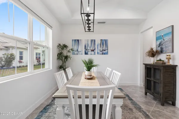 a living room with furniture kitchen view and a chandelier