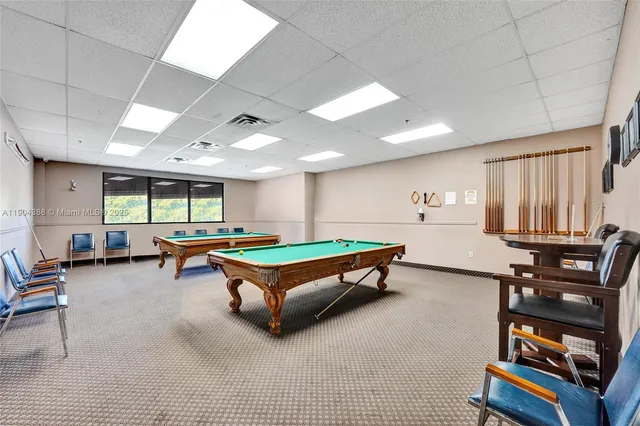 a room with furniture pool table and windows