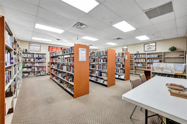 a view of a room with lots of furniture and white walls