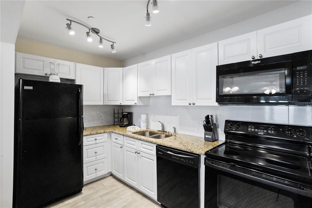 13500 Gulf Boulevard, Unit 505 Madeira Beach, FL 33708 - Photo 13 of 42 a kitchen with a sink stove and microwave
