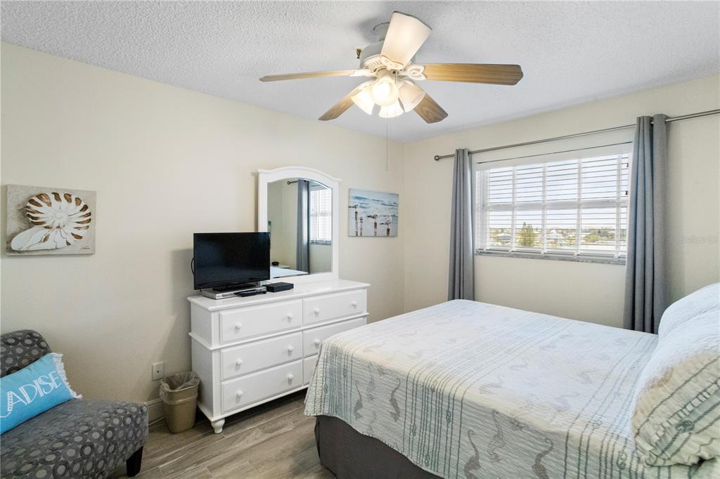 13500 Gulf Boulevard, Unit 505 Madeira Beach, FL 33708 - Photo 15 of 42 a bedroom with a bed and a television