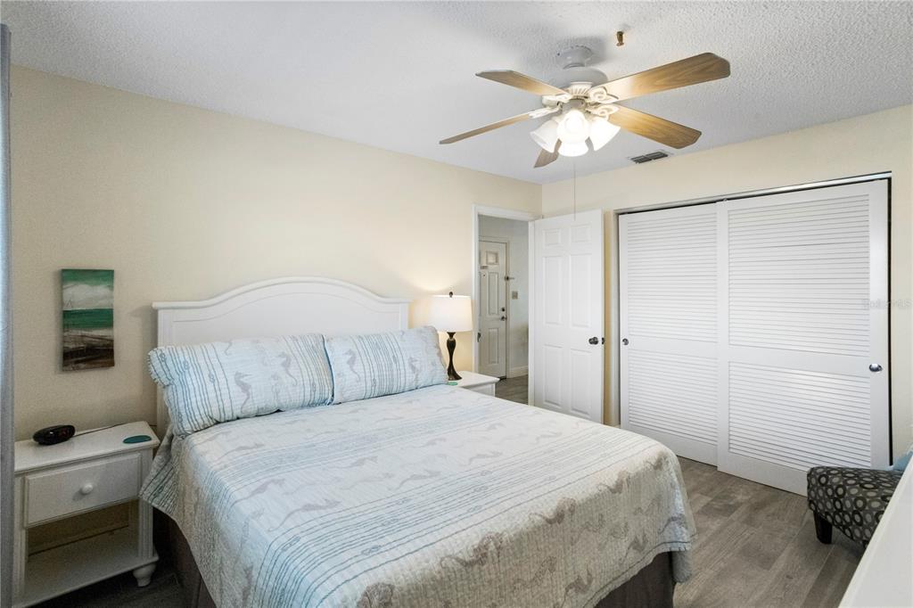 13500 Gulf Boulevard, Unit 505 Madeira Beach, FL 33708 - Photo 17 of 42 a bedroom with a large bed and a ceiling fan