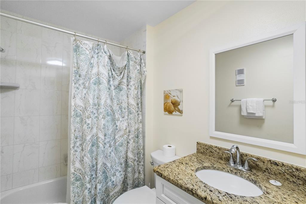 13500 Gulf Boulevard, Unit 505 Madeira Beach, FL 33708 - Photo 18 of 42 a bathroom with a granite countertop sink and a mirror