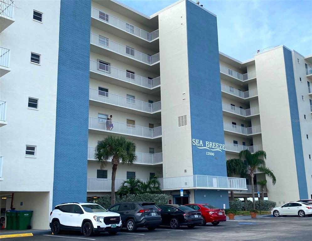 13500 Gulf Boulevard, Unit 505 Madeira Beach, FL 33708 - Photo 38 of 42 a cars parked in front of a building
