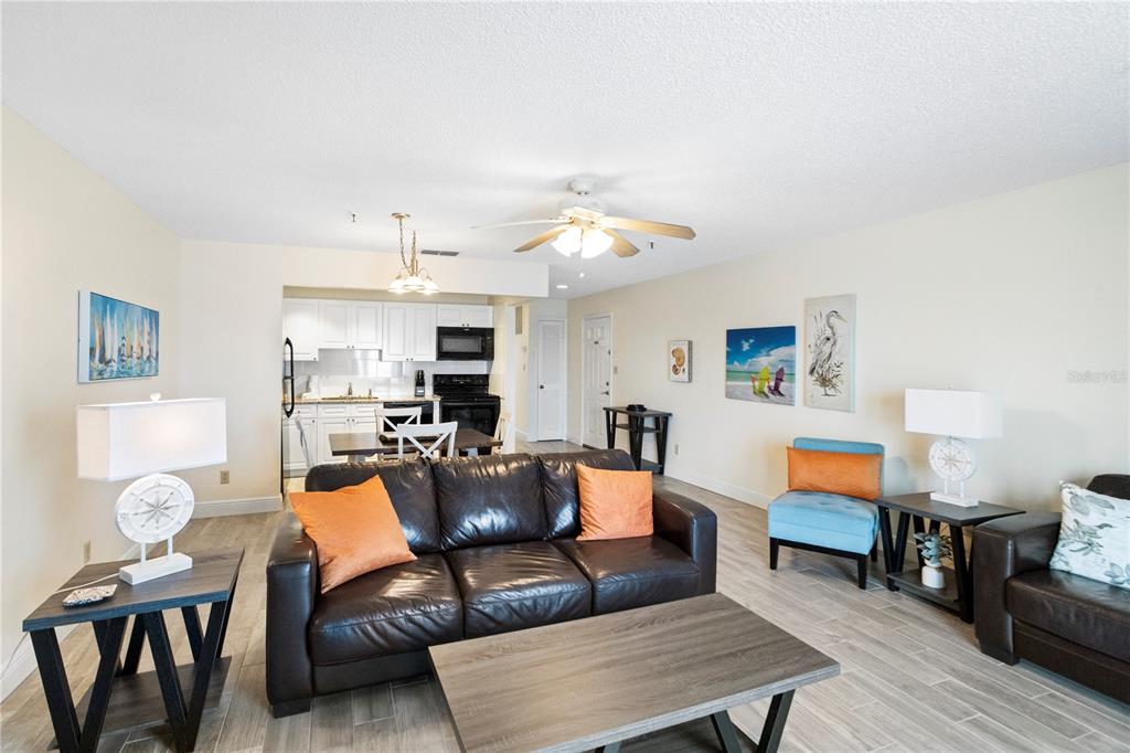 13500 Gulf Boulevard, Unit 505 Madeira Beach, FL 33708 - Photo 8 of 42 a living room with furniture a dining table and kitchen view