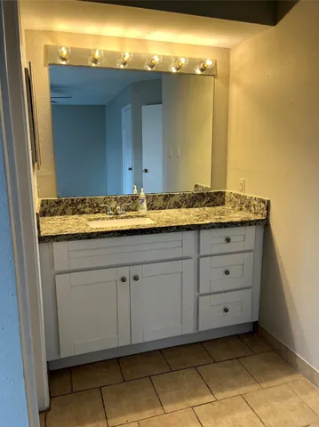 a bathroom with a sink vanity and mirror
