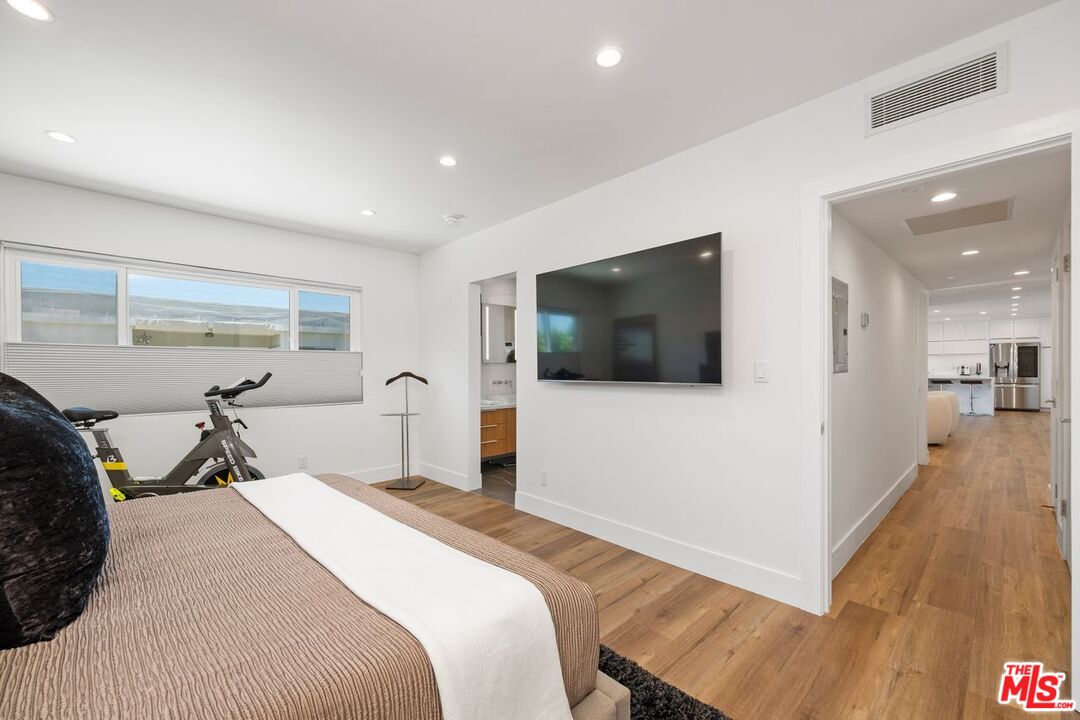 949 North Kings Road, Unit 302 West Hollywood, CA 90069 - Photo 13 of 16 a bedroom with a bed and a flat screen tv