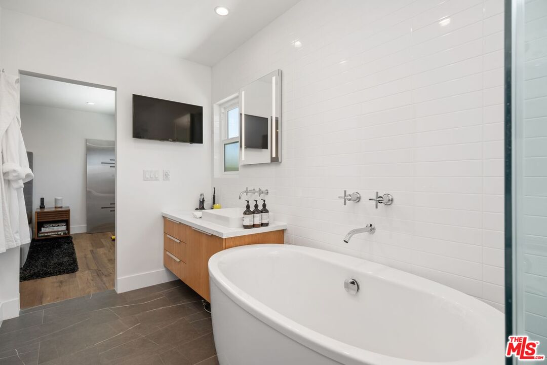 949 North Kings Road, Unit 302 West Hollywood, CA 90069 - Photo 16 of 16 a white bath tub sitting next to a bathroom sink