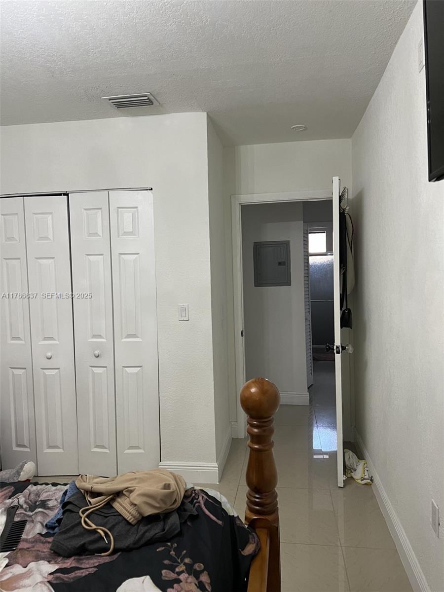 7225 Southwest 21st Street Miami, FL 33155 - Photo 8 of 16 a bedroom with a bed and a chandelier