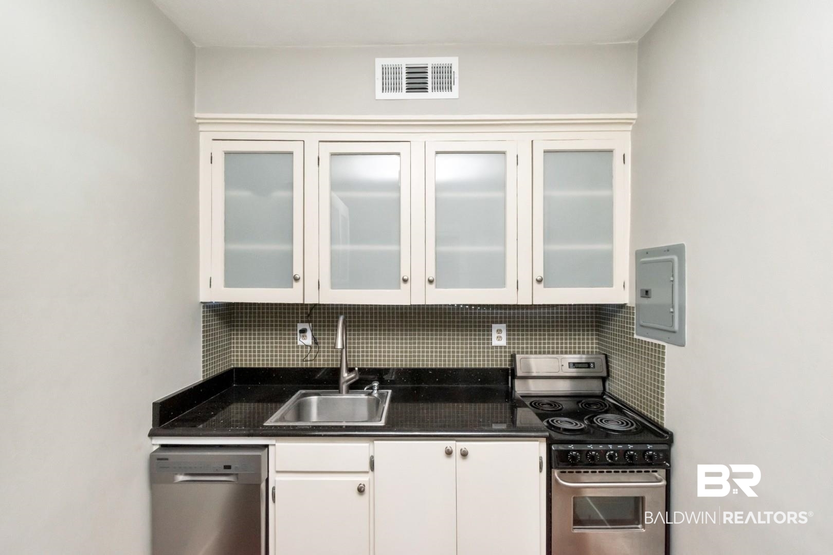 1602 Government Street, Unit 1A Mobile, AL 36604 - Photo 10 of 24 Kitchen featuring appliances with stainless steel finishes, white cabinets, tasteful backsplash, electric panel, and glass insert cabinets