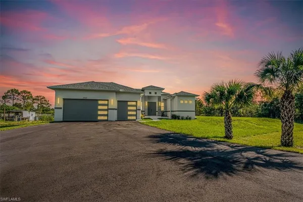 a front view of a house with a yard and garage
