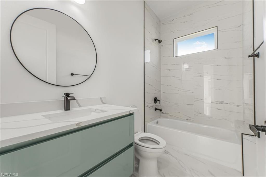 2941 37th Avenue Northeast Naples, FL 34120 - Photo 33 of 46 a bathroom with a sink a toilet and a mirror