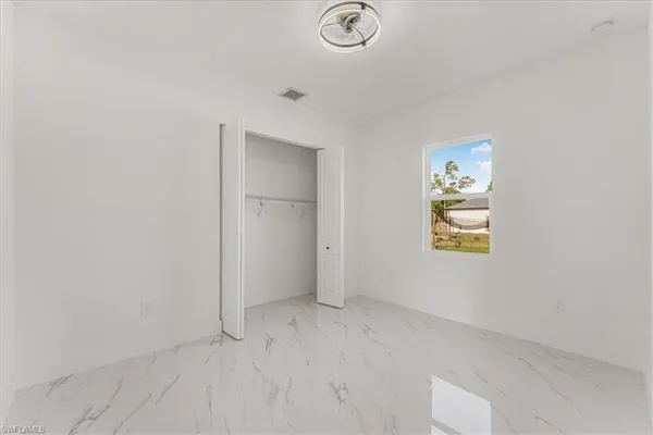 a view of an empty room with cabinet and mirrors