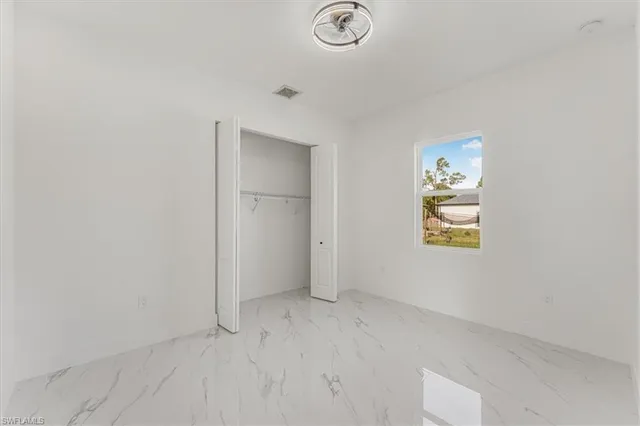 a view of an empty room with cabinet and mirrors