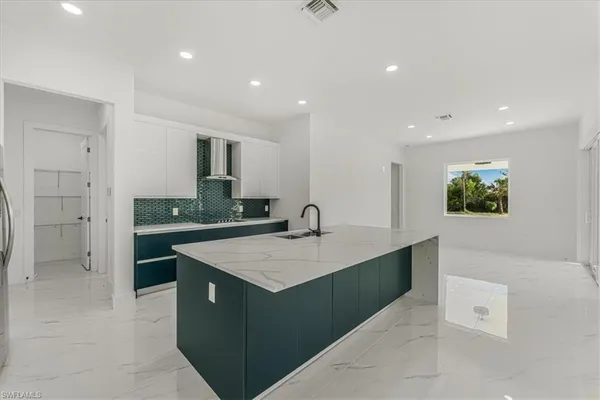 a kitchen with stainless steel appliances kitchen island granite countertop a refrigerator and a stove top oven