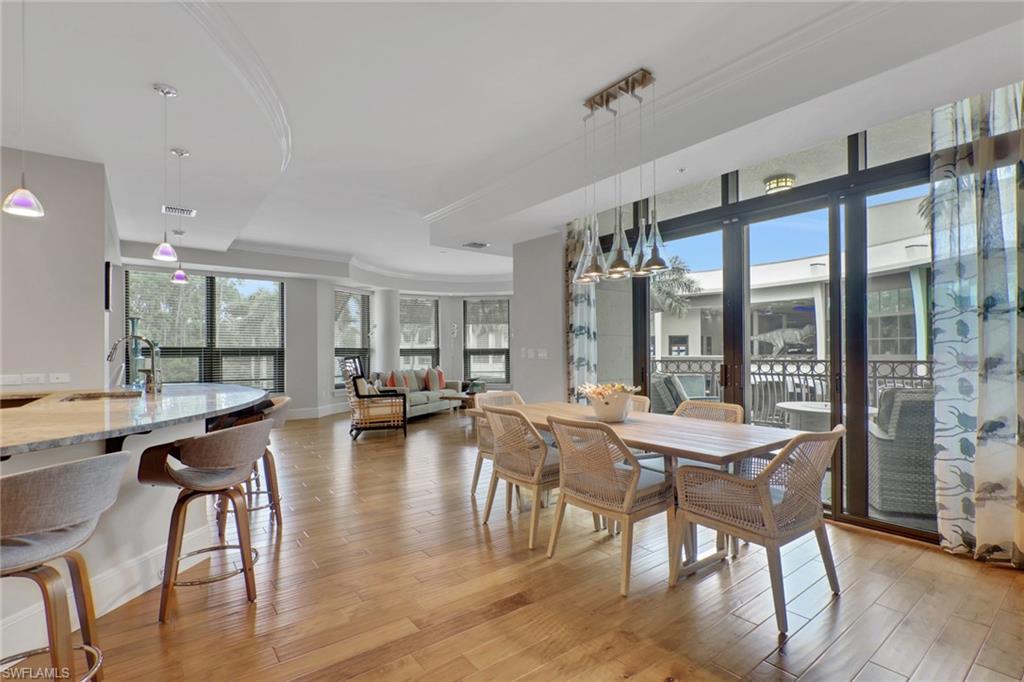 Dining space with ornamental molding and light wood-style flooring