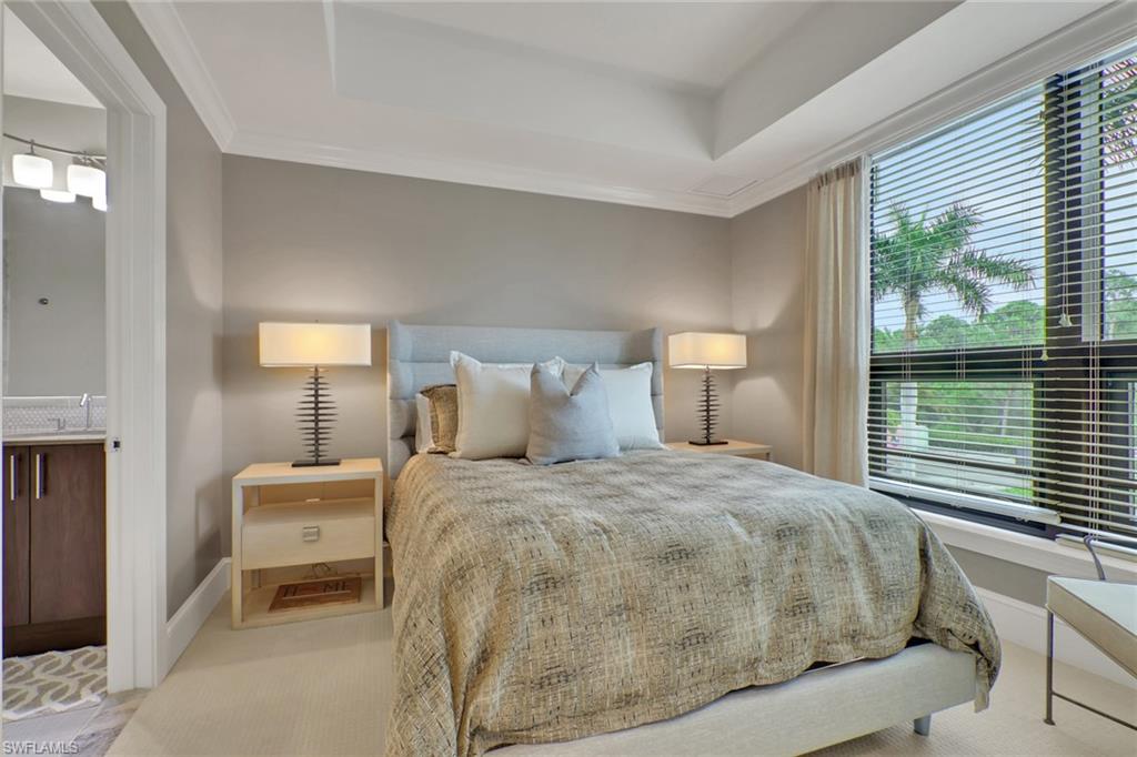 9123 Strada Place, Unit 7216 Naples, FL 34108 - Photo 13 of 28 Bedroom featuring ornamental molding, a tray ceiling, and carpet flooring